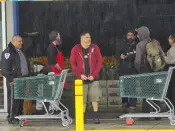 Whole Foods Market workers walk outdoors after a temporary power outage in the Silver Lake area of Los Angeles Wednesday, March 15, 2023. Southern California residents weary of a storm-soaked winter were hit Wednesday by parting shots from the season's 11th atmospheric river, which flooded roadways, caused mudslides and toppled trees throughout the state. (AP Photo/Damian Dovarganes)