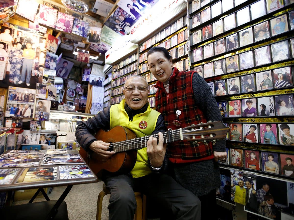 Kazuhiko Kobayashi, 80, and his wife Mieko Kobayashi, 73, pose for a photograph at their music shop named Ameyoko Rhythm, specialised for Enka, traditional Japanese popular ballad, in Tokyo's Ameyoko shopping district, Japan, February 8, 2018. 