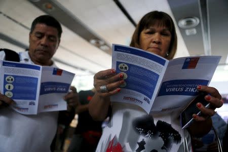 People read zika virus flyers from an information campaign by the Chilean Health Ministry at the departures area of Santiago's international airport, Chile January 28, 2016. REUTERS/Ivan Alvarado