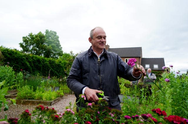 Liberal Democrat leader Sir Ed Davey picks a bloom at Shropshire Flower Farm during a visit to Whitchurch 