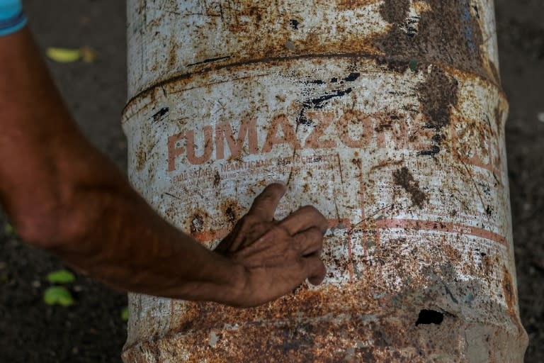 Le travailleur agricole Pedro Fletes montre des bidons rouillés, qui contenaient le pesticide DBCP, le 11 mai 2022 à Tonala, au Nicaragua