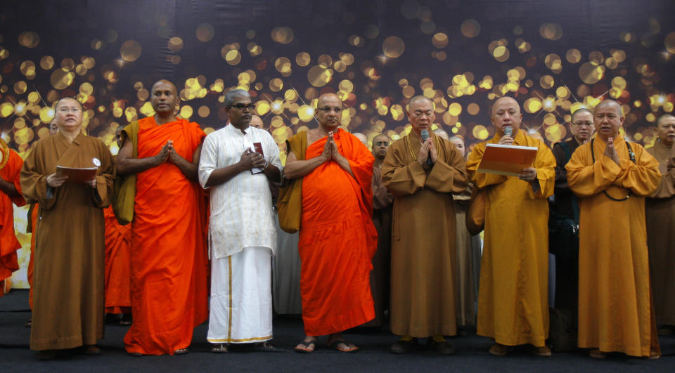 Monjes budistas ofrecen una oración por los pasajeros del avión malayo perdido, en el Aeropuerto Internacional de Kuala Lumpur en Sepang, Malasia, el domingo 9 de marzo de 2014. (Foto AP/Lai Seng Sin)