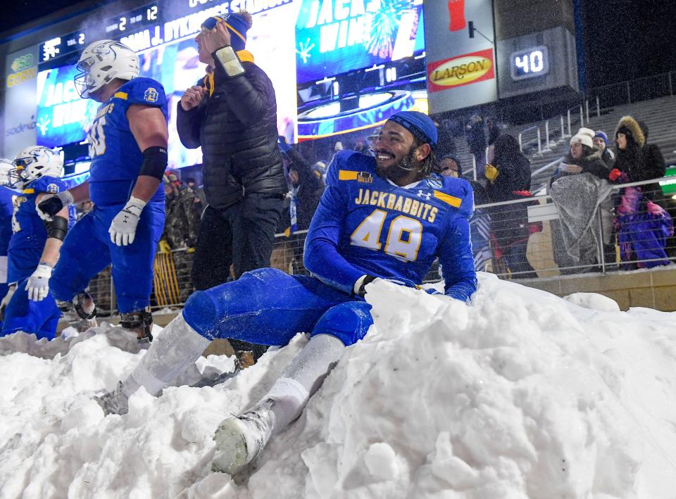 South Dakota State’s Quinton Hicks leans back in a snow pile while celebrating the team’s victory over Montana State in the FCS semifinals on Saturday, December 17, 2022, at Dana J. Dykhouse Stadium in Brookings, SD.