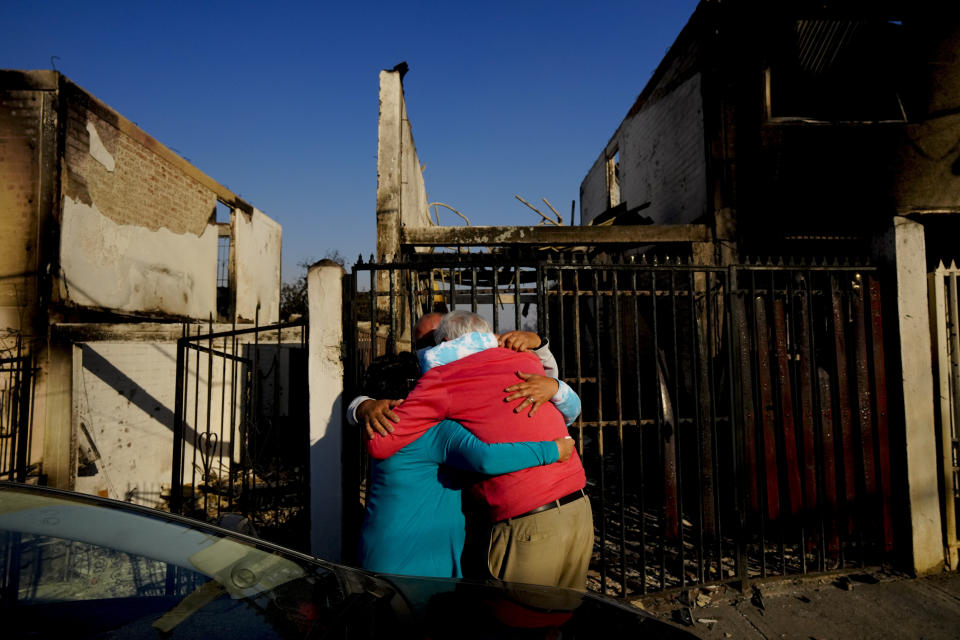 Residents embrace each other after a forest fire reached their neighborhood, in Vina del Mar, Chile, Saturday, Feb. 3, 2024. (AP Photo/ Esteban Felix)