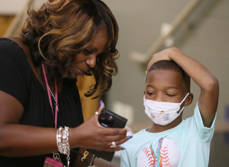 Helen Arnold Principal Lamonica Davis shows a video to Tyren Thompson as he visits the school for the first time since being shot following a pee wee football game in Akron.