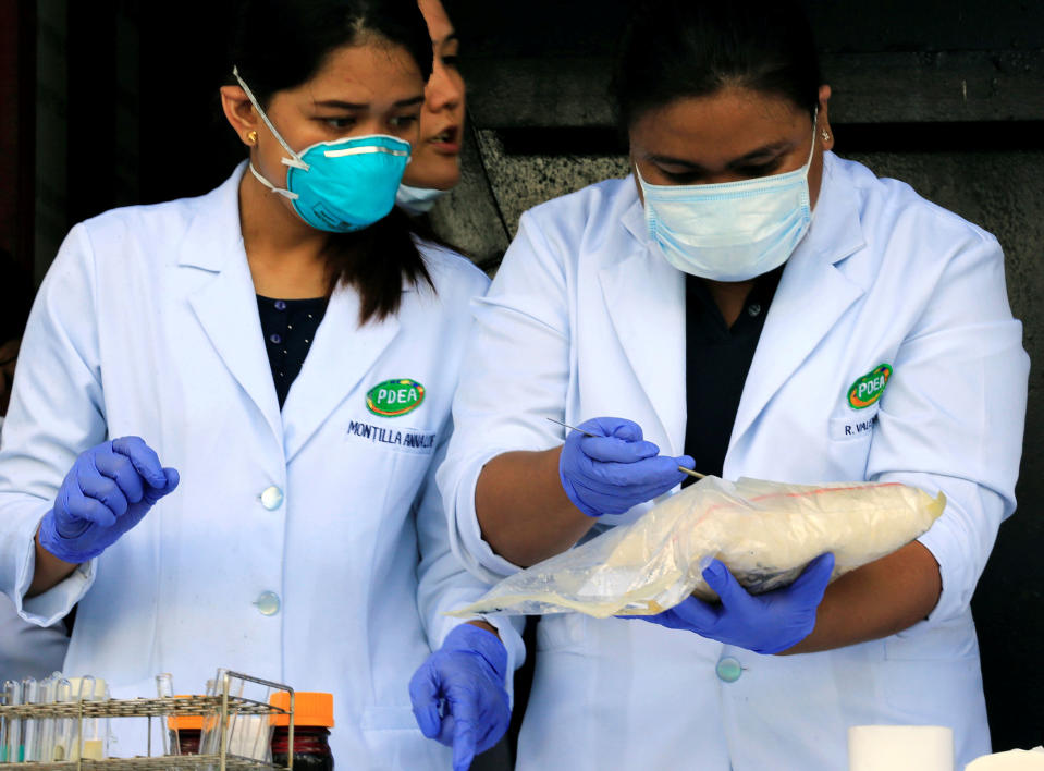 <p>Members of the laboratory service from the Philippine Drug Enforcement Agency (PDEA) test samples of the methamphetamine hydrochloride, locally referred as Shabu, during the destruction of confiscated illegal drugs at a waste management facility in Trece Martires town, Cavite, south of Manila on July 14, 2016. (REUTERS/Romeo Ranoco) </p>