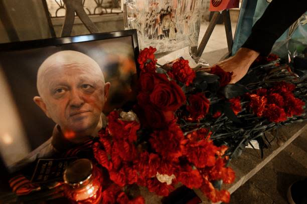 A man lays flowers at the makeshift memorial in honor of Yevgeny Prigozhin (AFP via Getty Images)