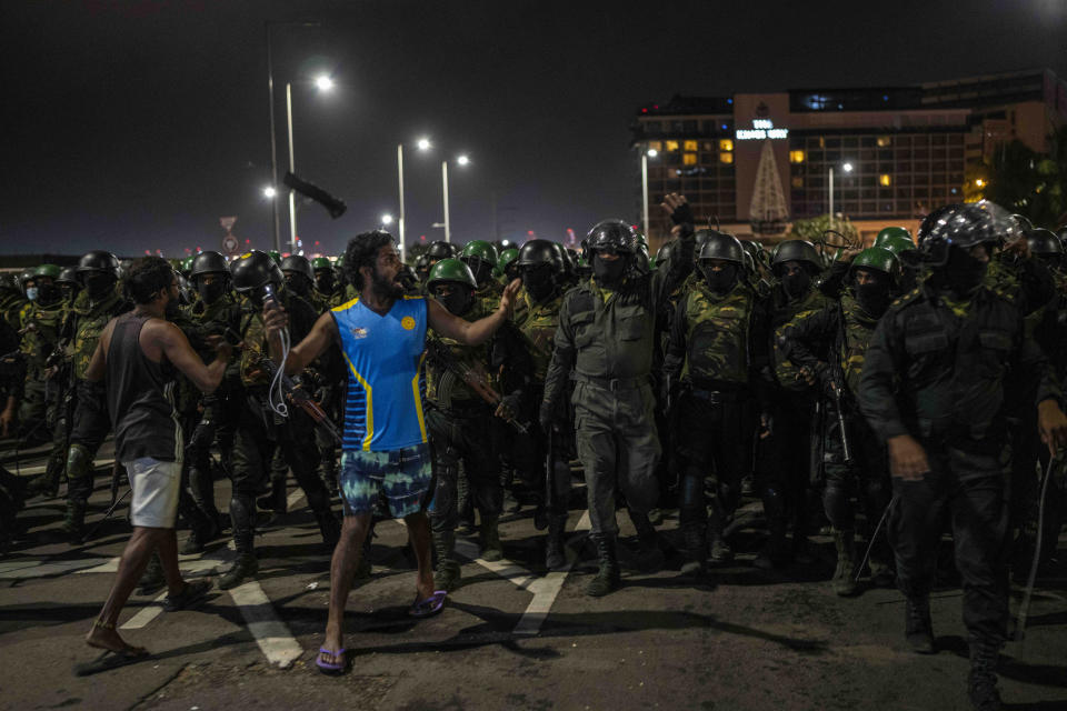 A protester shouts slogans as army soldiers arrive to remove protesters from the site of a protest camp outside the Presidential Secretariat in Colombo, Sri Lanka, Friday, July 22, 2022. (AP Photo/Rafiq Maqbool)