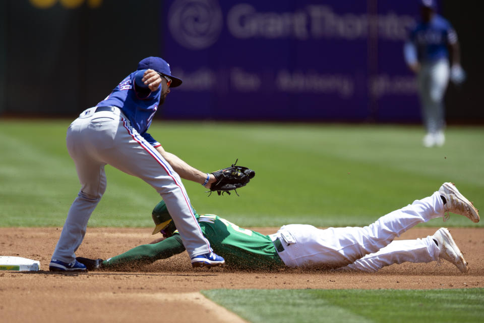 Oakland Athletics' Starling Marte (2) slides safely into second with a stolen base, under the tag of Texas Rangers shortstop Isiah Kiner-Falefa (9) during the first inning of a baseball game, Sunday, Aug. 8, 2021, in Oakland, Calif. (AP Photo/D. Ross Cameron)