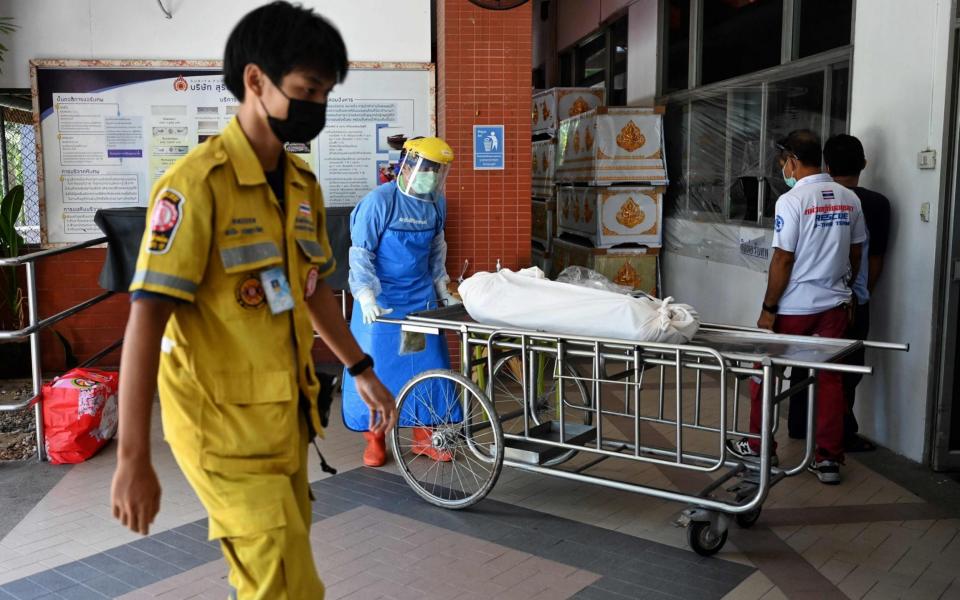 A hospital worker transports a body to a morgue in Pathum Thani province, Thailand on 17 July 2021 - Lillian Suwanrumpha/AFP