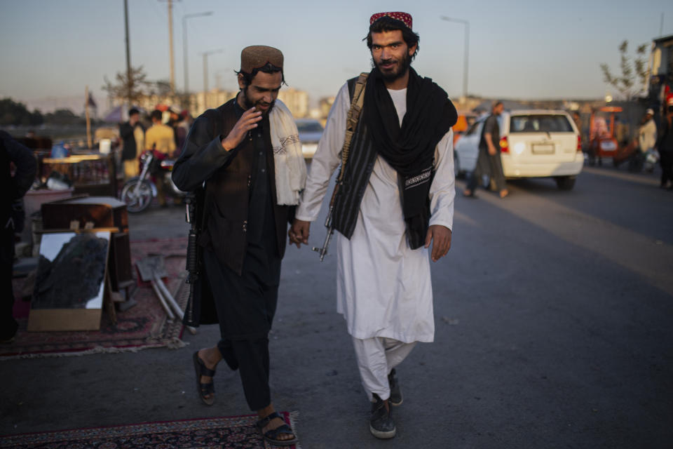 Taliban fighters walk through a market in Kabul, Afghanistan, Tuesday, Oct. 12, 2021. (AP Photo/Ahmad Halabisaz)