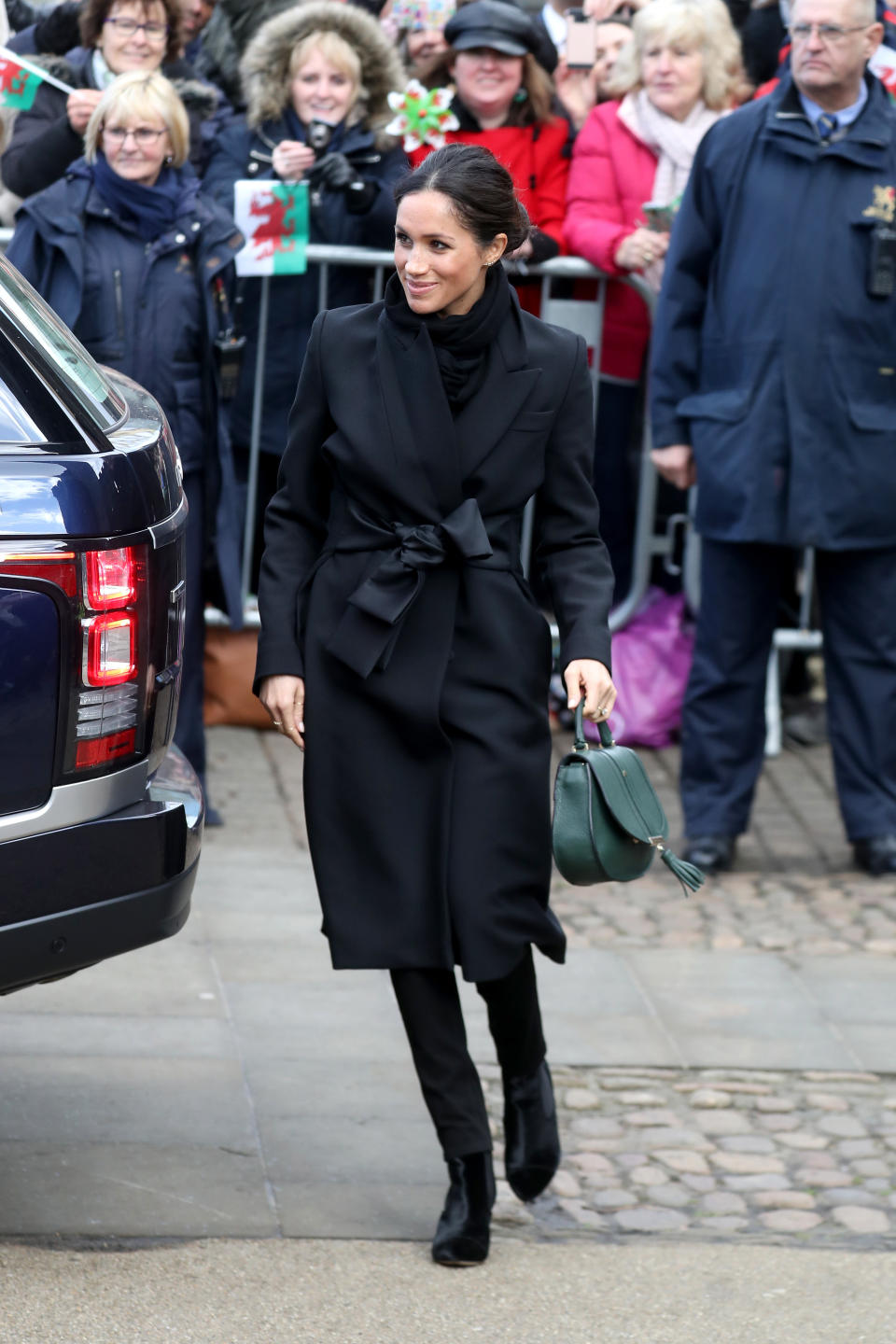 <p>Für ihre erste offizielle Reise nach Cardiff wählte Meghan Markle eine Hose der walisischen Marke Hiut Denim. Sie vervollständigte das Ensemble ganz in Schwarz mit einem Stella McCartney-Mantel mit Satingürtel und einer waldgrünen Handtasche von DeMellier.<em> [Bild: Getty]</em> </p>