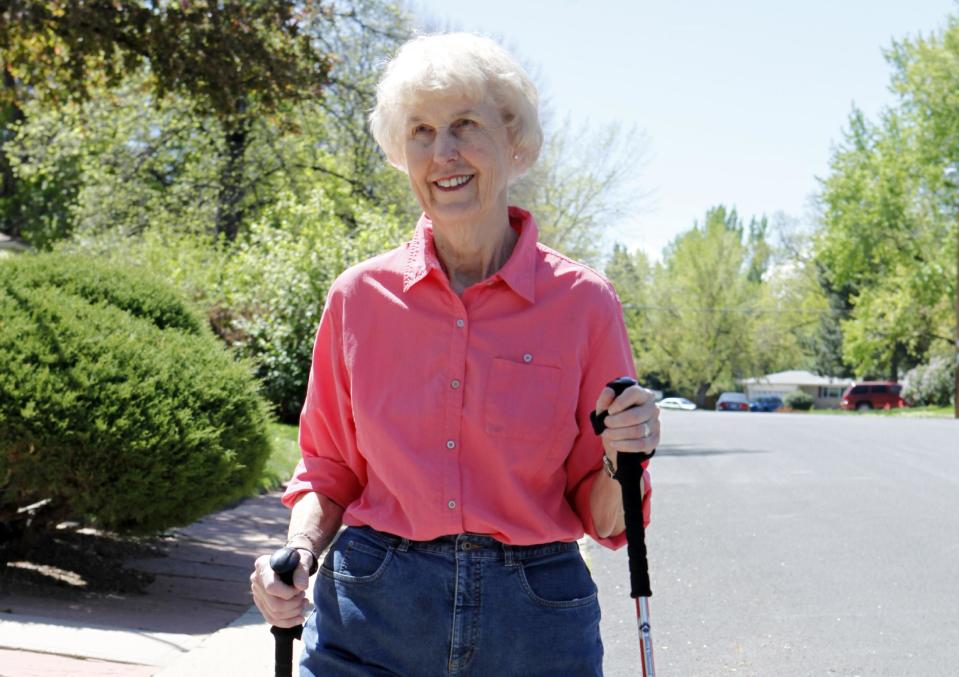 In this photo taken on April 23, 2012, Elaine Vlieger, 79, walks near her home near Denver, Colo. Vlieger is making some concessions to her early stage Alzheimer's, but isn't ready to give up either her home or her independence. She stays active with yard work and daily walks. (AP Photo/Ed Andrieski)