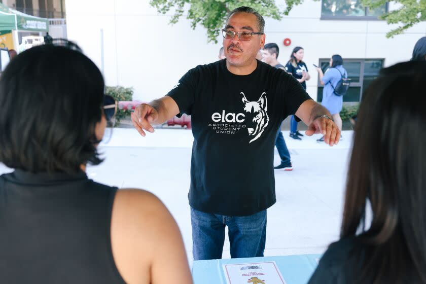 Student body president at East Los Angeles College, Steven Gallegos, center, informs stalls about a photobooth.