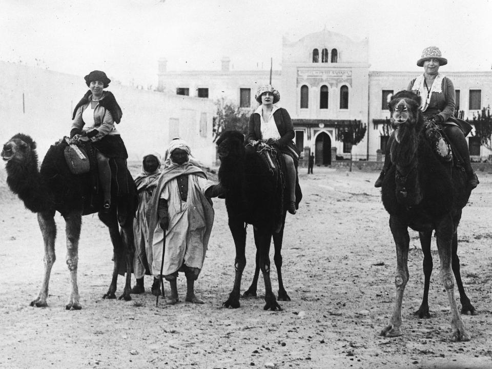 Tourists Ride Camels in the Sahara