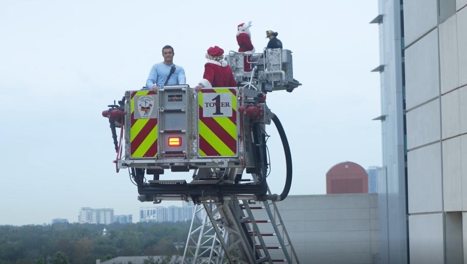 Firefighters and police officers surprised children and their families in the sixth annual Holiday Elf rappelling event.