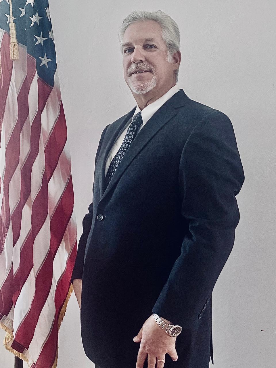 Tim Moshier stands next to the American flag.