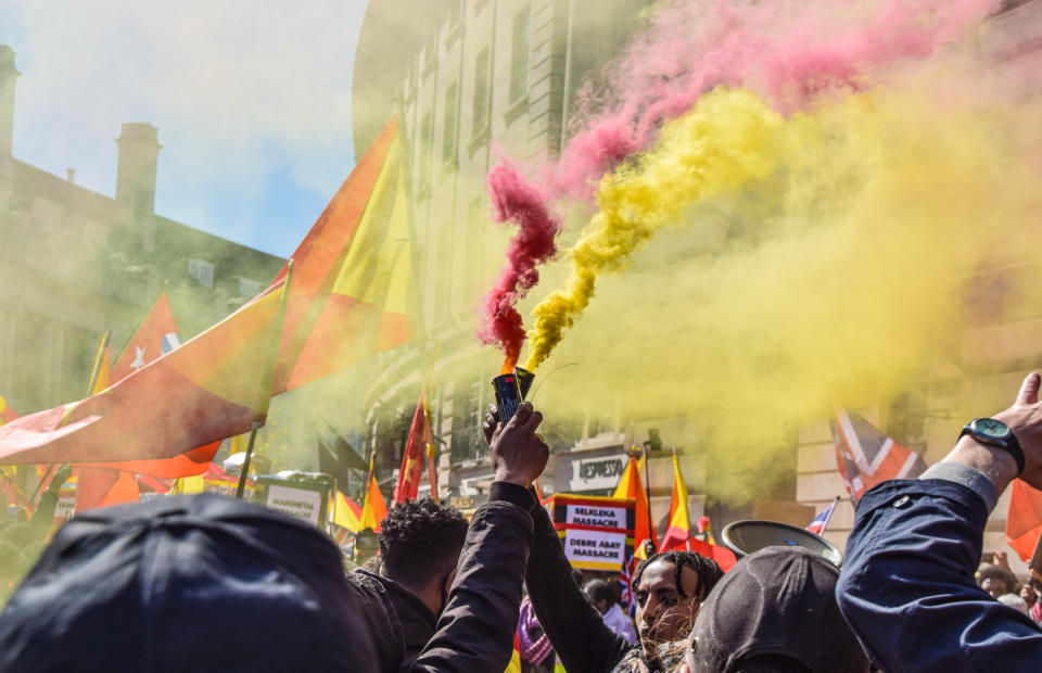 <p>LONDON, UNITED KINGDOM - 2021/04/25: Protesters hold smoke flares during the demonstration. Thousands of people marched through Central London in protest of what the demonstrators call Ethiopia's and Eritrea's "genocidal war" on the region of Tigray. (Photo by Vuk Valcic/SOPA Images/LightRocket via Getty Images)</p>
