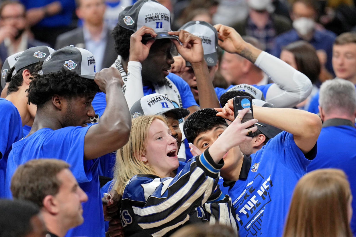 Mar 26, 2022; San Francisco, CA, USA; Carlyn Savarino (center), granddaughter of Duke Blue Devils head coach Mike Krzyzewski (not pictured) takes a selfie with the team as they celebrate their win over the Arkansas Razorbacks in the finals of the West regional of the men's college basketball NCAA Tournament at Chase Center. The Duke Blue Devils won 78-69. Mandatory Credit: Kelley L Cox-USA TODAY Sports