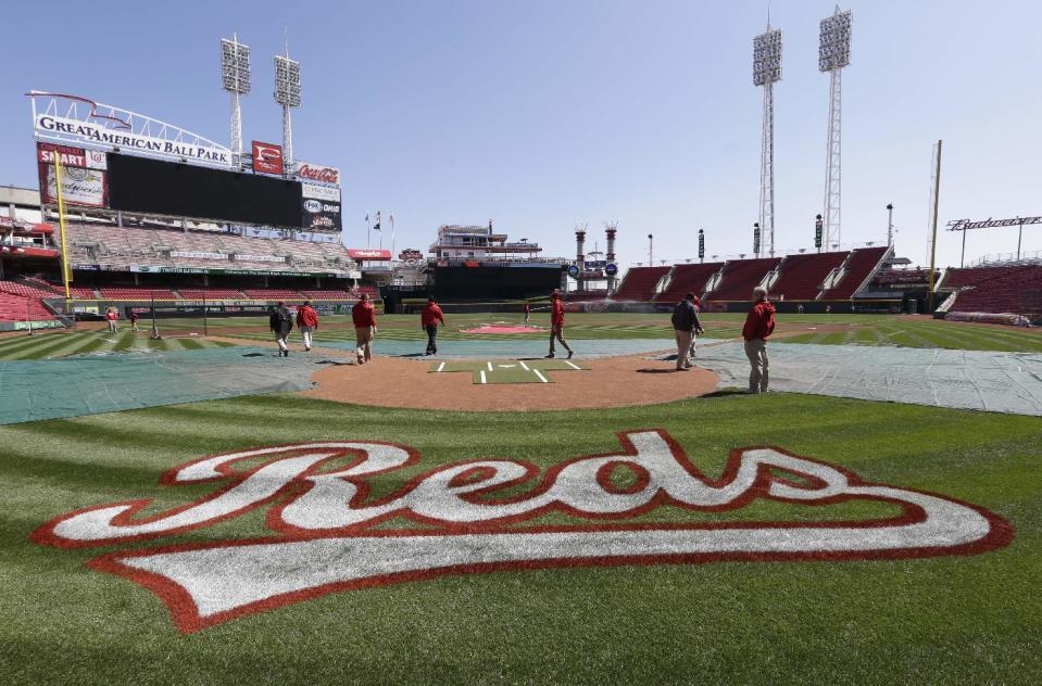 The Cincinnati Reds grounds crew checks the field on Sunday, March 30, 2014, in Cincinnati. The Reds host the St. Louis Cardinals, Monday afternoon in their Opening Day baseball game. (AP Photo/Al Behrman)
