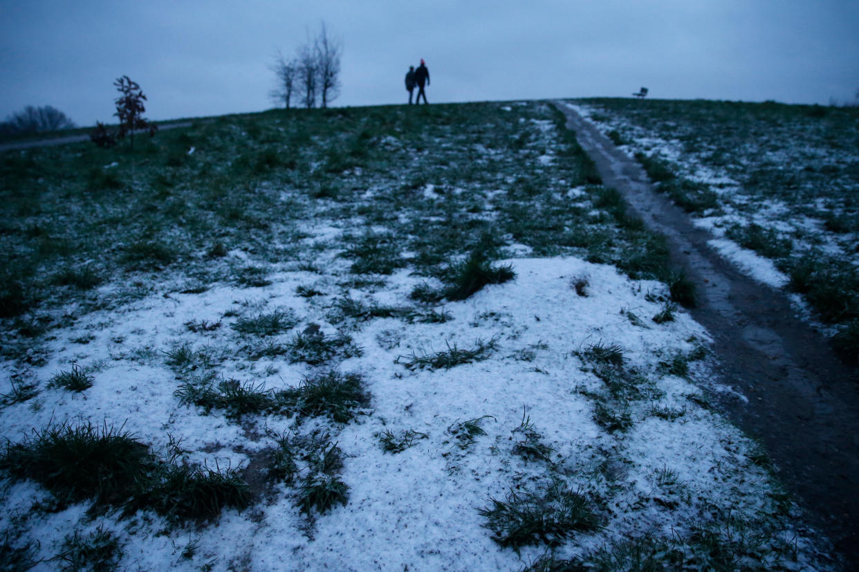 <p>People walk early morning on a partially snow covered Parliament Hill in Hampstead</p> (Getty Images)