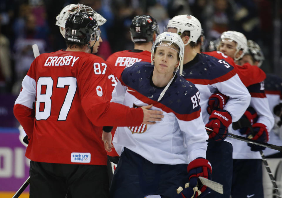 Canada forward Sidney Crosby consoles USA forward Patrick Kane after Canada won 1-0 in a men's semifinal ice hockey game at the 2014 Winter Olympics, Friday, Feb. 21, 2014, in Sochi, Russia. (AP Photo/Julio Cortez)