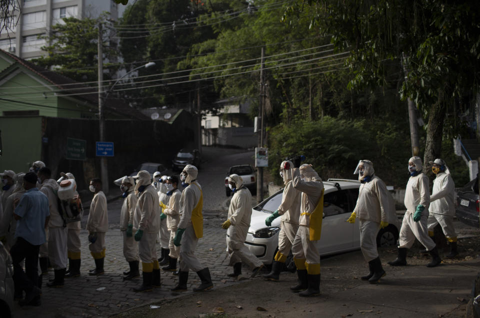Water utility workers from the CEDAE prepare to disinfect the Turano favela in an effort to curb the spread of the new coronavirus in the Tuesday, June 9, 2020. (AP Photo/Silvia Izquierdo)