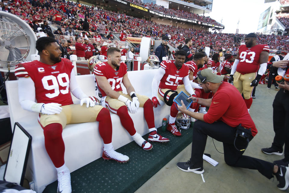 Niners defensive line coach Kris Kocurek talks with DeForest Buckner (99), Nick Bosa (97) and Dee Ford on the sideline during the divisional round. (Photo by Michael Zagaris/San Francisco 49ers/Getty Images)