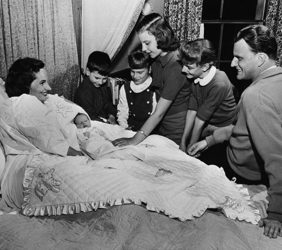 <p>Rev. Billy Graham says goodbye to his wife, Ruth, and their five children on Jan. 15, 1958, before leaving on a crusade in eight Latin American countries. (Photo: AP) </p>