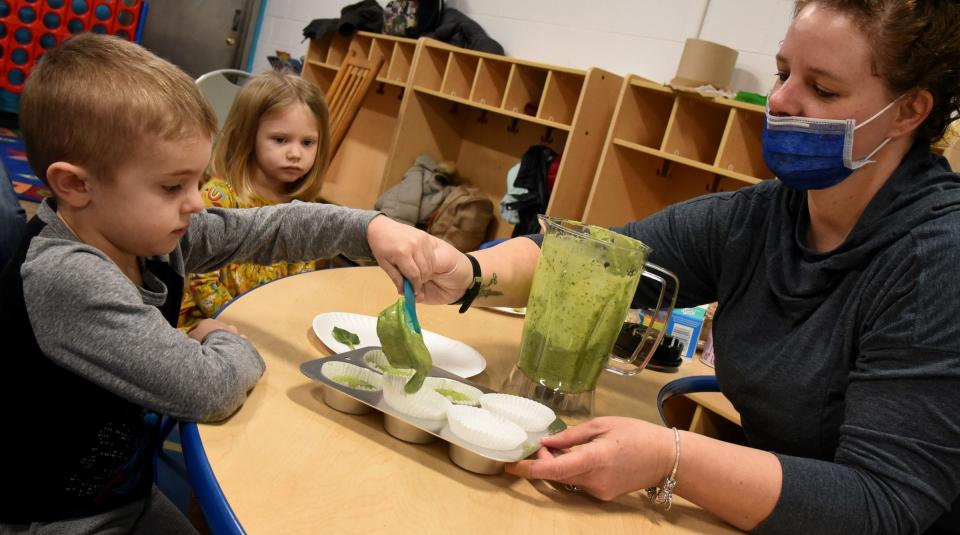 Preschooler Logan Opfermann, 4, and Ellie Nowitzke, 3, ladel out the liquid from the blender to bake for the  monster green avocado, turkey and egg bites with Monroe Family YMCA Youth Outreach Director Carrie Powell.