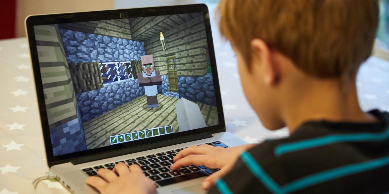 child playing minecraft on laptop computer