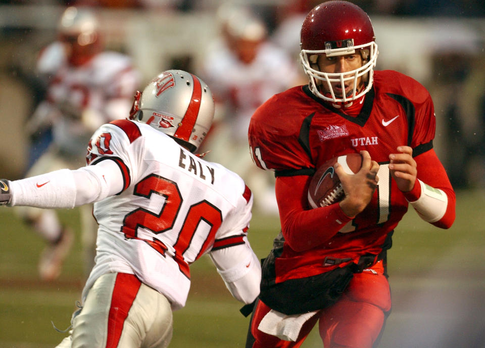 Utah quarterback Alex Smith (11) eludes the tackle by UNLVs Charles Ealy (20) enroute to a 70 yard touchdown during the first quarter Saturday, Oct. 23, 2004 at Rice - Eccles Stadium in Salt Lake City, Utah. (Photo by Ken Levine/Getty Images)