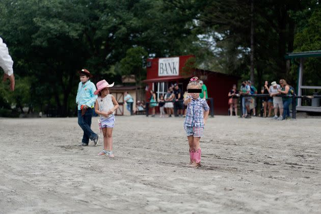 A young girl pretends to shoot me with her toy gun during an audience participation skit at Wild West City.