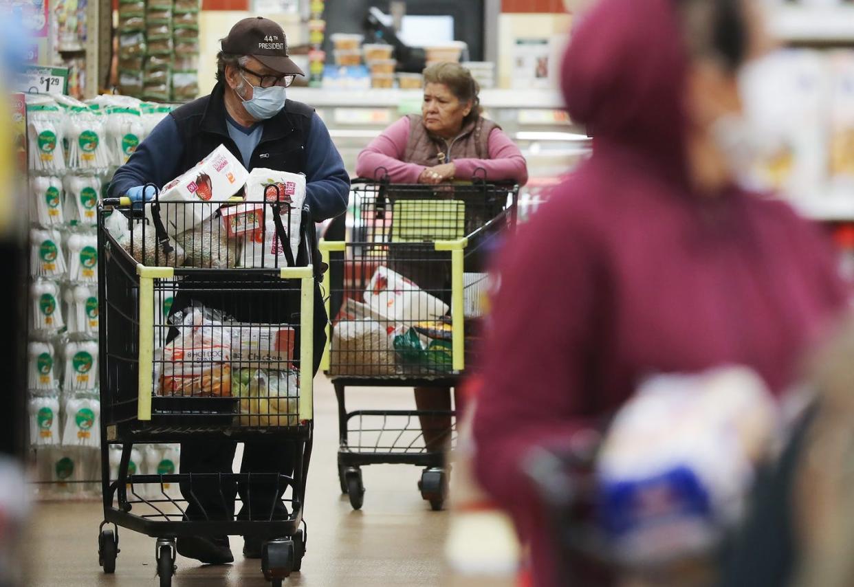 <span class="caption">Masks and social distancing can help protect shoppers from the coronavirus, but gloves aren't recommended.</span> <span class="attribution"><a class="link " href="http://gettyimages.com" rel="nofollow noopener" target="_blank" data-ylk="slk:Mario Tama/Getty Images;elm:context_link;itc:0;sec:content-canvas">Mario Tama/Getty Images</a></span>