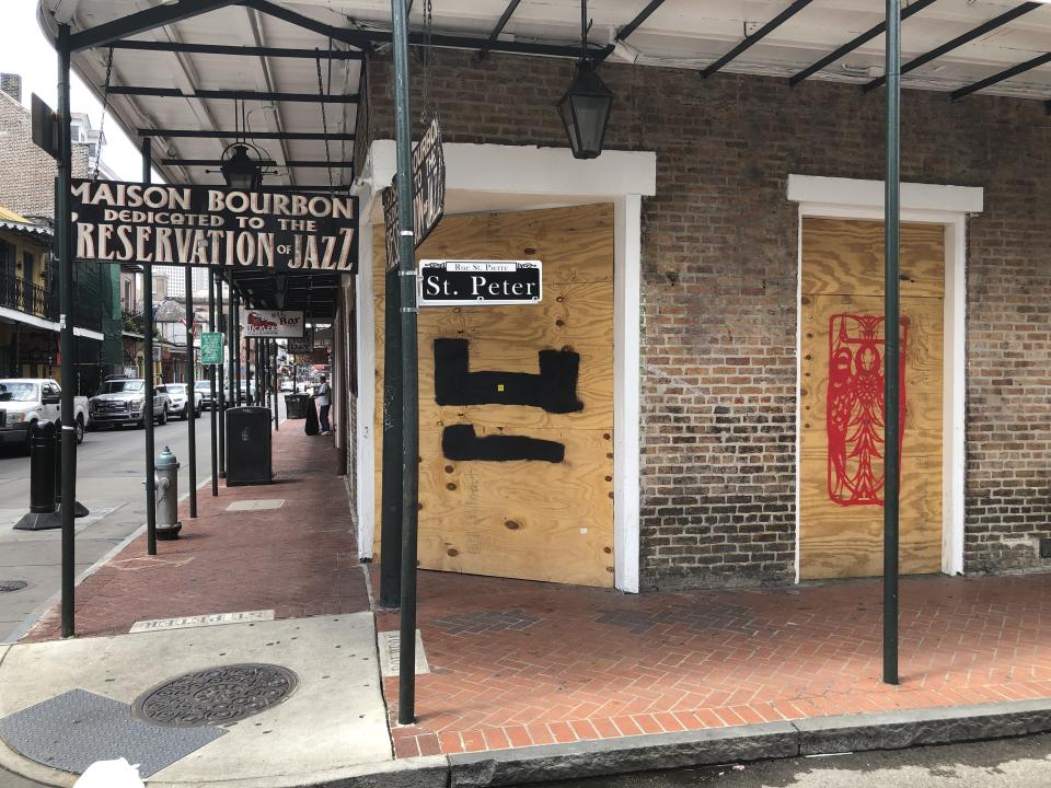 In this Wednesday, May 20, 2020 photo, a bar is boarded-up at a Bourbon Street intersection in New Orleans’ French Quarter. Bars have been closed in New Orleans since early March because of the coronavirus pandemic. Some residents of the historic French Quarter, while acknowledging the economic pain and suffering, say the lack of tourists has been a relief. (AP Photo/Kevin McGill)