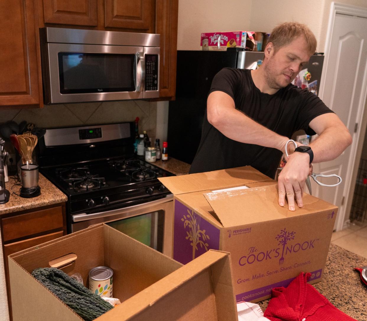 Dana Lindahl unpacks a box delivered as part of Ascension Seton Medical Center's Food is the Best Medicine program. In addition to Farmshare Austin's fresh produce, Cook's Nook provides ready-to-eat meals.