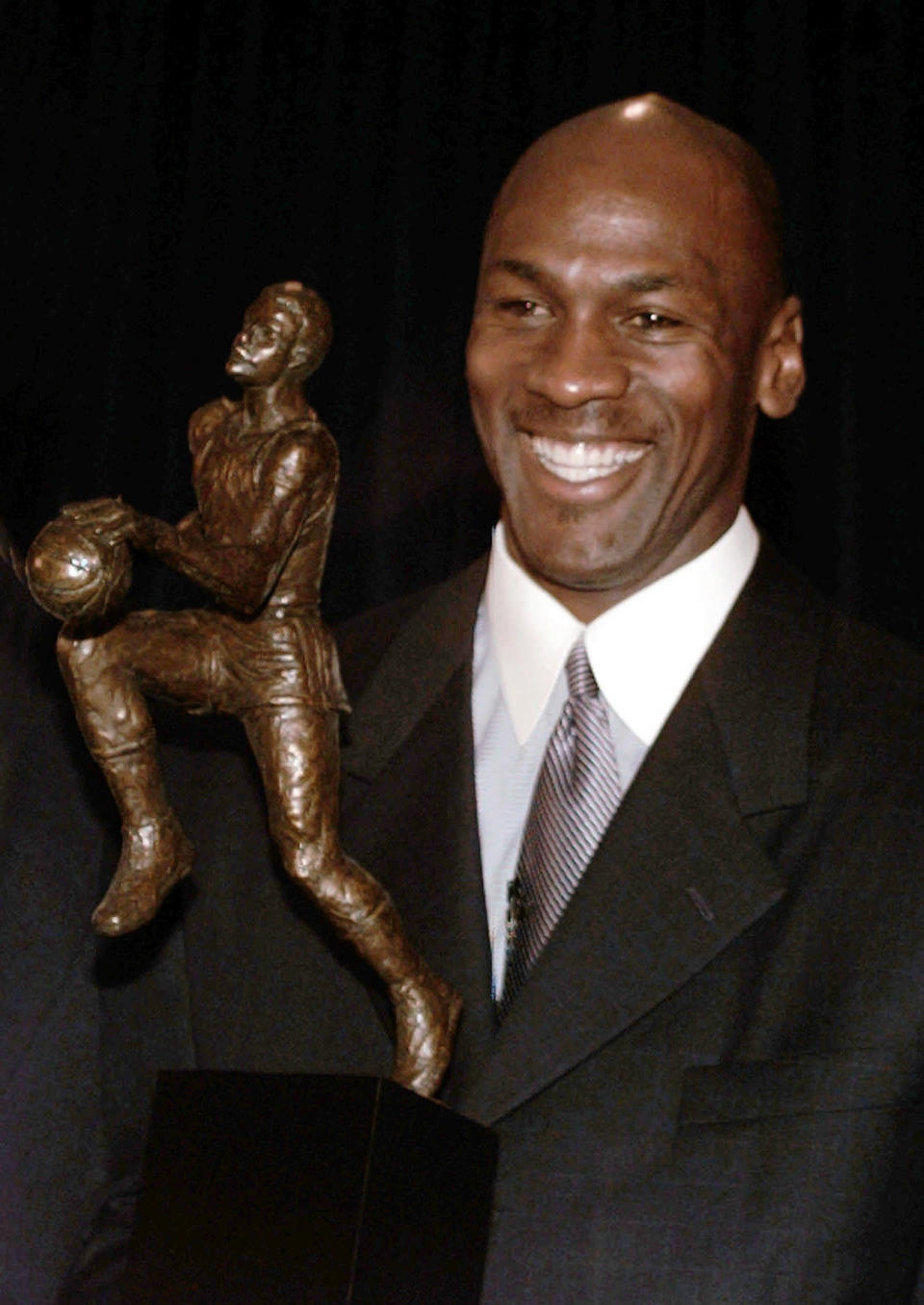 FILE - Chicago Bulls' Michael Jordan holds the Maurice Podoloff Trophy awarded to the NBA basketball Most Valuable Player for the 1995-96 season in Northbrook, Ill., May 20, 1996. The trophy carried Podoloff's name for about 60 years, and has now been reimagined and renamed for Jordan. (AP Photo/Charles Bennett, File)