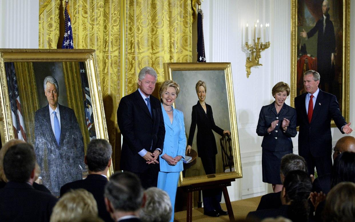 Bill Clinton Hillary Clinton stand by their offical White House portraits during the unveiling event hosted by President George W. Bush and First Lady Laura Bush in 2004 - AFP