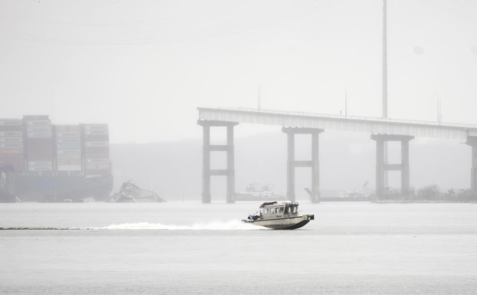 A boat crosses along the Patapsco River, Wednesday, March 27, 2024, as the remnants of the Francis Scott Key Bridge are seen from Dundalk, Md. (Kaitlin Newman/The Baltimore Banner via AP)