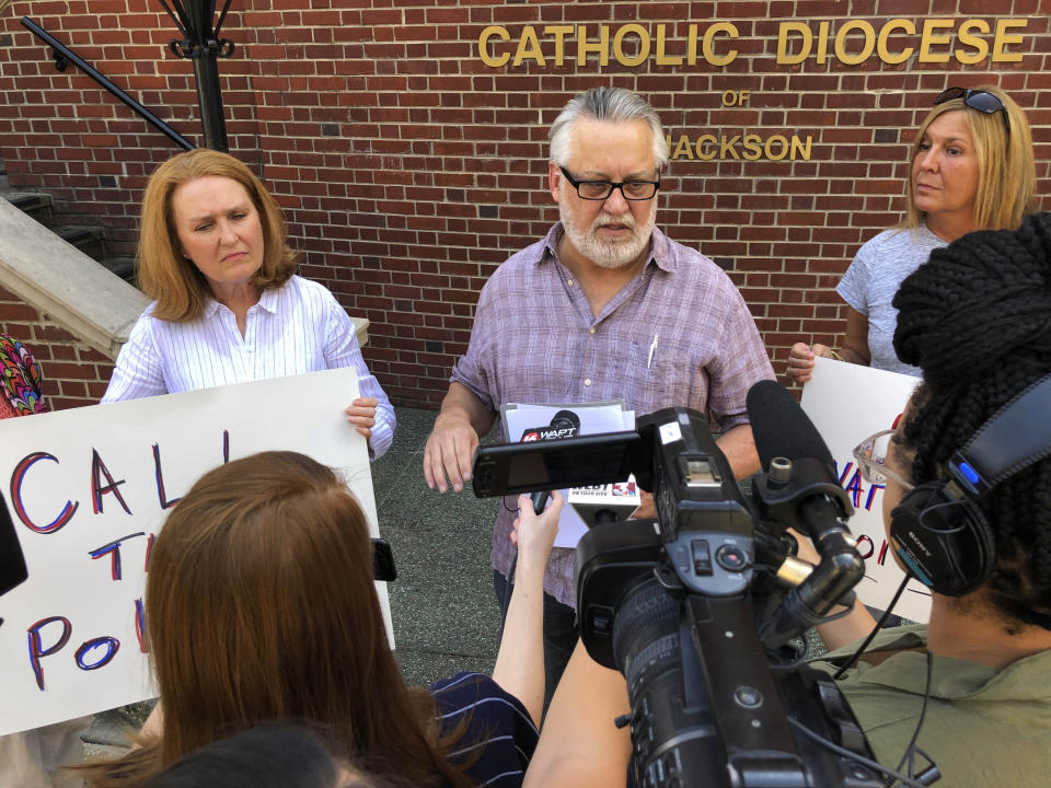 Mark Belenchia, center, says Thursday, Aug. 29, 2019, that he wants federal authorities to investigate the Catholic Diocese of Jackson, Miss., over the way the diocese settled abuse claims for three men in the Mississippi Delta. Belenchia is the volunteer coordinator in Mississippi for SNAP, Survivors Network for those Abused by Priests. He is joined by his wife, Lisa Belenchia, left, and another supporter, Jen DuBois. (AP Photo/ Emily Wagster Pettus)