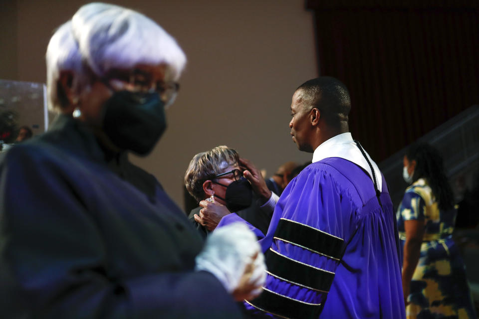 Rev. Dante Quick, applies oil for healing to a woman as he preaches during a church service at the First Baptist Church of Lincoln Gardens on Sunday, May 22, 2022, in Somerset, N.J. In Black, Asian American, Pacific Islander, Latino and other communities of color, the church is the sacred village that binds people of faith to their roots, history and traditions. It is natural for congregants to reach out to faith leaders for comfort in times of crisis. But these overwhelming duties, which most pastors are ill-equipped to handle, have led to exhaustion and burnout raising questions about how clergy members can better care for their own mental well-being while helping congregants. (AP Photo/Eduardo Munoz Alvarez)