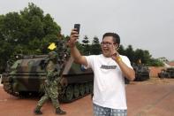 A local resident takes a selfie with his smartphone in front of military soldiers and tanks during the annual Han Kuang military exercise in Kinmen, Taiwan, September 7, 2015. REUTERS/Pichi Chuang