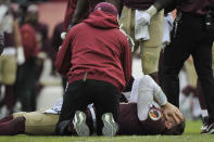 FILE - Washington Redskins quarterback Alex Smith, bottom, reacts after an injury during the second half of an NFL football game against the Houston Texans in Landover, Md., in this Sunday, Nov. 18, 2018, file photo. Smith announced his retirement Monday, April 19, 2021, on Instagram, saying he still has plenty of snaps left him just shy of his 37th birthday but is calling it quits to enjoy time with his family. Smith earned AP Comeback Player of the Year honors for getting back on the field last season, two years removed from his gruesome injury that required 17 surgeries to repair. (AP Photo/Mark Tenally, File)