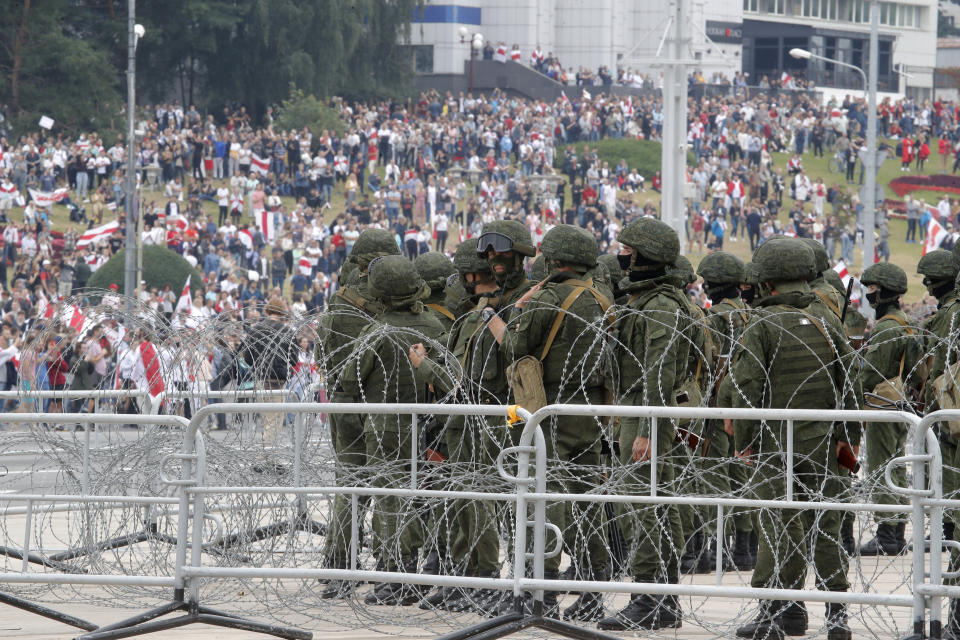 Riot policemen block the area during protests in Minsk, Belarus, Sunday, Aug. 23, 2020. More than 100,00 protesters demanding the resignation of Belarus' authoritarian president are rallying in a vast square in the capital, continuing the massive outburst of dissent that has shaken the country since dubious presidential elections two weeks ago. (AP Photo/Dmitri Lovetsky)