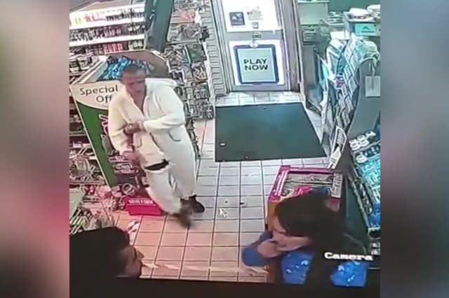 A thug dressed in a unicorn onesie confronted a shopkeeper while a woman spat in his face