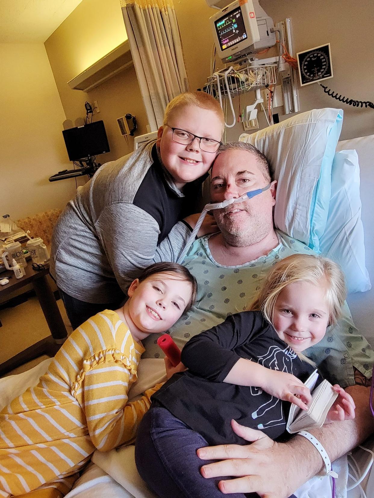Josh Kilpatrick enjoys time with three of his children — Kholby, Shannley and Abigail Kilpatrick — as he battled COVID pneumonia in OSF St. Mary Medical Center on Jan. 23.