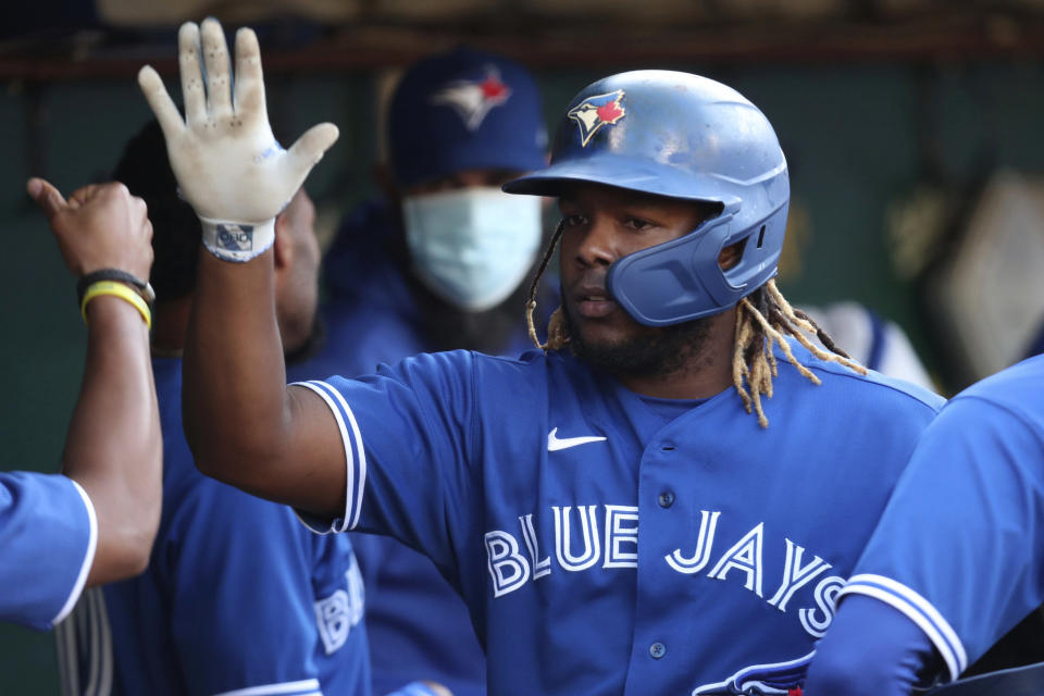 Toronto Blue Jays' Vladimir Guerrero Jr. is congratulated by teammates after scoring on a single by Randal Grichuk against the Oakland Athletics during the first inning of a baseball game in Oakland, Calif., Wednesday, May 5, 2021. (AP Photo/Jed Jacobsohn)