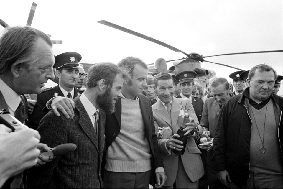 Roger Mallinson (left) and Roger Chapman watch as a bottle of champagne is opened after their rescue from the Atlantic seabed. <em>Photo by PA Images via Getty Images</em>