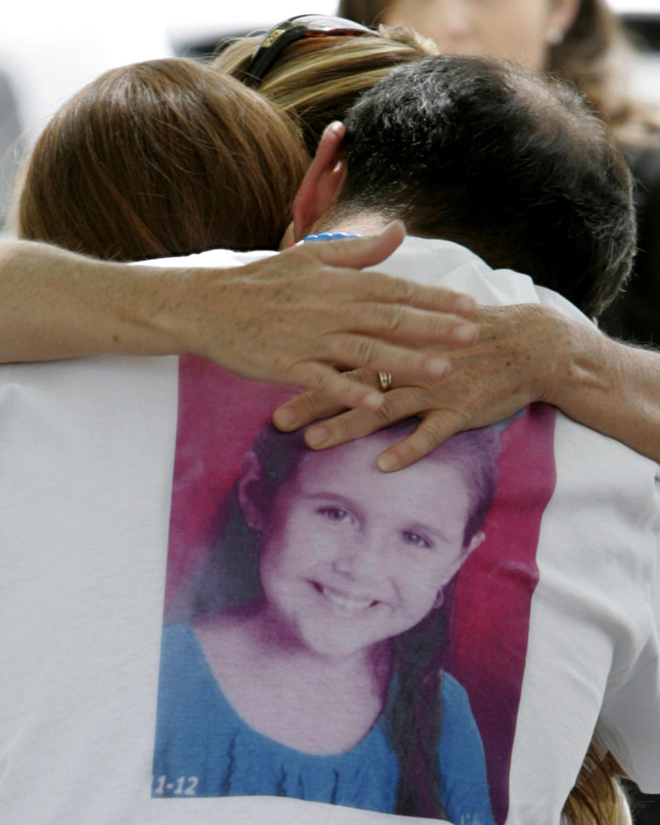 FILE - In this April 25, 2012, file photo, Sergio Celis, wearing a shirt with a picture of his missing 6-year-old daughter, Isabel, gets a hug from a volunteer near their home in Tucson, Ariz. Arizona officials say Christopher Matthew Clements was indicted on Friday, Sept. 14, 2018, in the kidnapping and killing of Isabel Celis in 2012 and 13-year-old Maribel Gonzalez in 2014. (A.E. Araiza/Arizona Daily Star via AP, File)