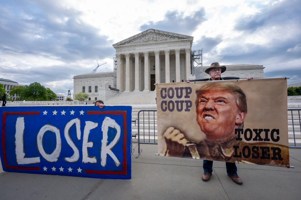 Activist Stephen Parlato of Boulder, Colo., right, joins other protesters outside the Supreme Court as the justices prepare to hear arguments over whether Donald Trump is immune from prosecution in a case charging him with plotting to overturn the results of the 2020 presidential election, on Capitol Hill in Washington, Thursday, April 25, 2024 (AP)